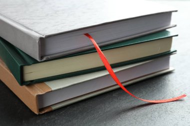 Kırmızı kurdele yer imi ve gri desenli masa üzerindeki renkli kitap, yakın plan.