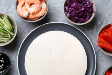 Pirinç kağıt çarşaflar ve açık gri masa üzerindeki farklı malzemeler, düz uzanmış.