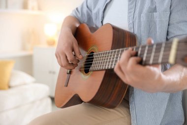 Evde gitar çalan adam, eline odaklan.