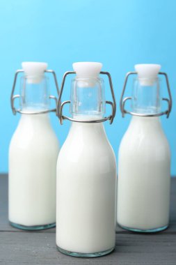 Tahta masada açık mavi arka plana karşı taze süt.