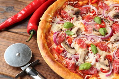 Tütsülenmiş sosisli lezzetli pizza ve ahşap masa, yakın plan.