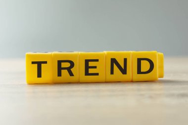 Masada harfler olan sarı küplerden oluşan kelime eğilimi