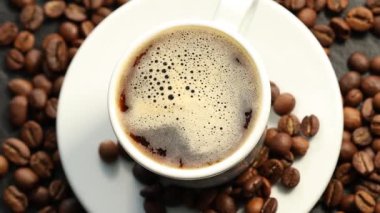 Aromatik kahve fincanda ve fasulye masada, düz yatıyordu.