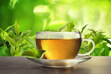 Çay çiftliğindeki gri masada bir fincan yeşil çay.