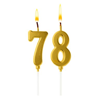 Beyaz arka planda 78 numarayı besteleyen yanan altın pasta mumları. Doğum günü veya diğer özel tarihler için şenlik dekorasyonu