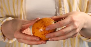 Olgun sarı çarkıfelek meyveli kadın, yakın plan.