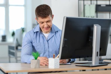 Ofiste masa başında çalışan yakışıklı adam.