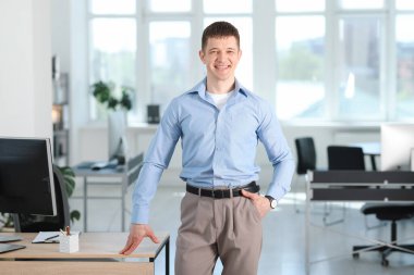 Ofisteki masanın yanındaki yakışıklı adamın portresi.