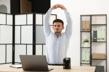 Ofiste sandalyeye uzanan yakışıklı adam.