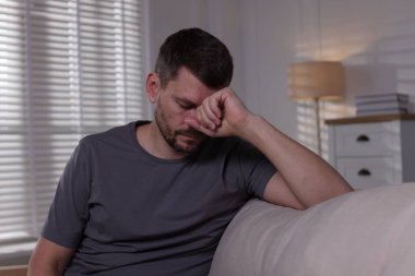 Evdeki kanepede depresif bir adam. Zihinsel sağlık sorunu