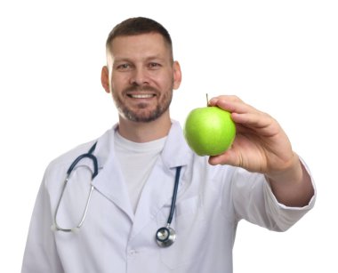 Beyaz arka planda yeşil elmalı ve steteskoplu beslenme uzmanı, seçici odaklı