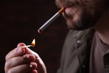 Arka planda kibrit yakan adam, yakın plan.