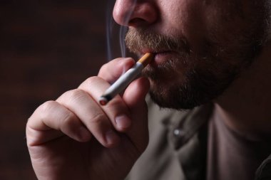 Arka planda sigara içen adam, yakın plan.