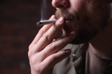 Arka planda sigara içen adam, yakın plan.