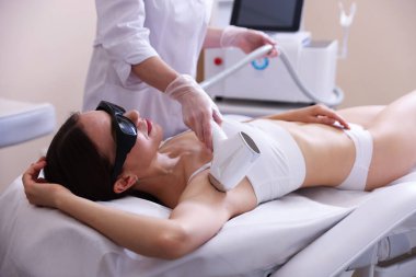 Güzellik salonunda lazer tüy temizleme işlemi sırasında kadın, yakın plan.