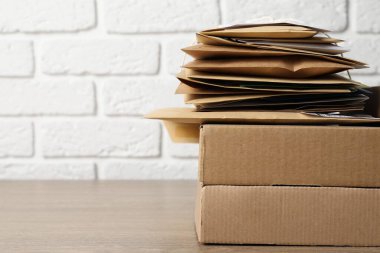 Postane. Tahta masadaki farklı kağıt zarflar ve paketler, yakın plan. Metin için boşluk