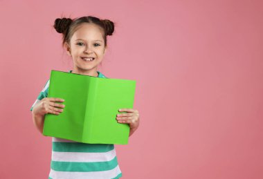 Pembe arka plan kitabı olan hoş bir kız, mesaj için boş yer.