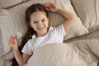 Yatakta uzanmış tatlı bir kız, yukarıda.