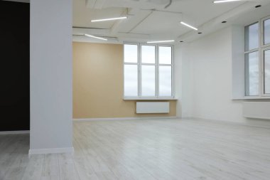 Temiz pencereleri ve aydınlık duvarları olan yeni boş oda