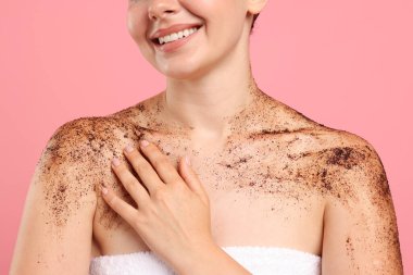 Cildini pembe arka plana sürten gülümseyen kadın, yakın plan.