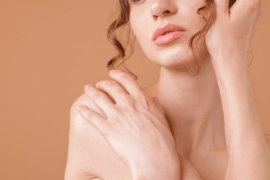 Bej arka planda poz veren güzel kadın, yakın plan.