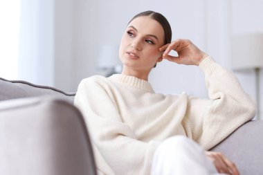 Evdeki kanepede güzel bir genç kadının portresi.