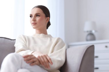 Evdeki kanepede güzel bir genç kadının portresi.