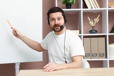 Çevrimiçi hoparlör, kapalı alanda web kamerasından görüntü, web tablosu yakınındaki webinar performansını sergiliyor.