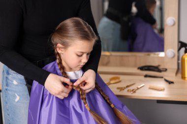 Güzel kız kuaförde güzel örgü örüyor.