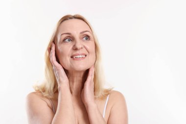 Beyaz arka planda gülümseyen orta yaşlı kadın. Metin için boşluk