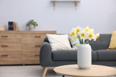 İçerideki ahşap masada vazodaki güzel nergisler, metin için yer.