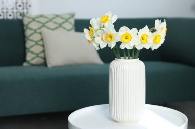 İçerideki masada vazodaki güzel nergisler, metin için yer.