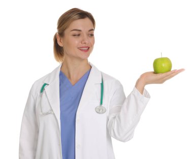 Beyaz arka planda yeşil elmalı ve steteskoplu beslenme uzmanı.