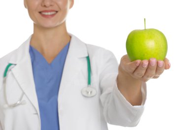 Beyaz arka planda yeşil elmalı ve steteskoplu beslenme uzmanı, yakın plan.