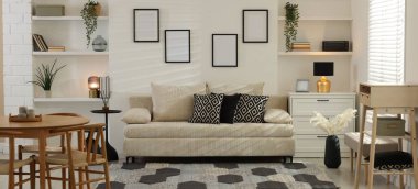 Rahat bir kanepe, masa, sandalyeler ve içeride şifonyer. İç tasarım