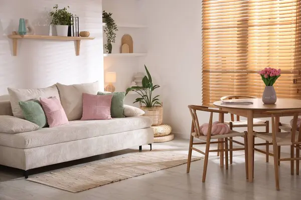 Odada rahat bir kanepe ve sandalyeli şık bir yemek masası. İç tasarım