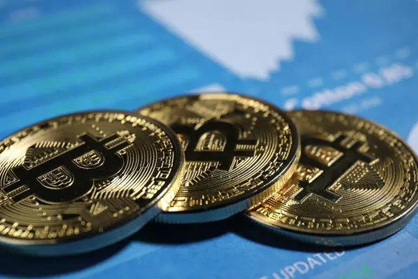 Kripto para birimi. Veri tablolarında üç bitcoin, yakın plan