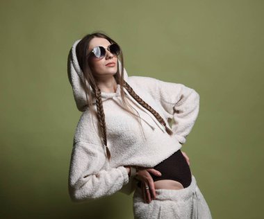 Yeşil arka planda şık giyinmiş güzel bir kadının moda portresi.