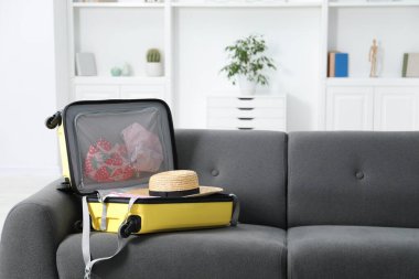 İçinde farklı giysiler olan bavulu kapalı koltukta aç.