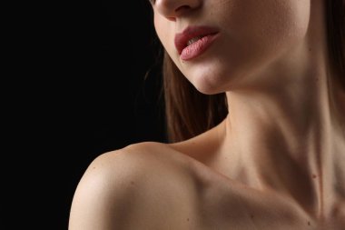 Siyah arka planda mükemmel bir cildi olan kadın, yakın plan.