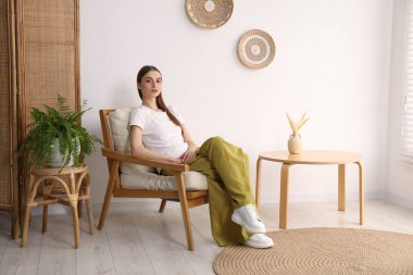 Evdeki rahat koltukta dinlenen güzel kadın.