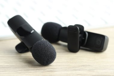 Lavalier mikrofonları ahşap masada, yakın plan. Ses ekipmanları