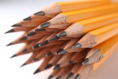 Açık arkaplanda keskin grafit kalemler, yakın plan