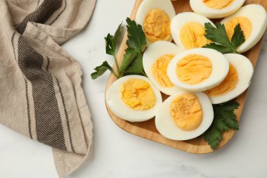 Beyaz mermer masada haşlanmış yumurta ve maydanoz.