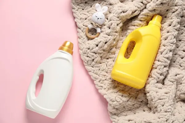 Pembe arka planda yumuşatıcı, oyuncak ve bebek battaniyesi.