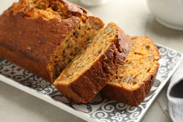 Açık gri masada fındıklı ev yapımı havuçlu kek, yakın plan.