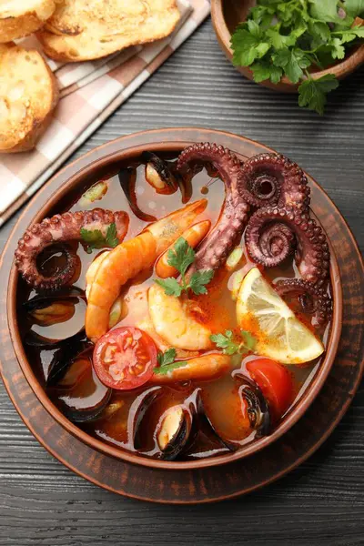 Tahta masada servis edilen lezzetli deniz ürünleri çorbası.