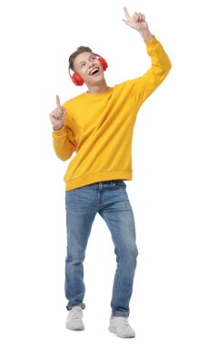 Kulaklıklı mutlu adam beyaz arka planda dans ediyor.