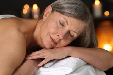 Masaj salonundaki masaj koltuğunda dinlenen son sınıf öğrencisi, yakın plan.