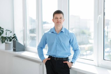 Pencerenin yanındaki yakışıklı adamın portresi.